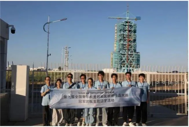团队在航天研学现场持横幅合影